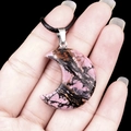 Pink and black crescent moon crystal pendant with natural texture on a black cord - 30mm Rhodonite