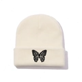 Close-up of fine butterfly embroidery on a cream knitted beanie with cuffed edge - One Size / Beige