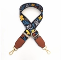 Dettaglio della tracolla nera a fiori con fibbie dorate e terminali in pelle marrone - Fibbia Oro / Motivo Floreale Nero e Giallo + Pelle Marrone