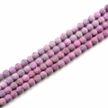 Makro-Detail von natürlichen lila Steinperlen mit matter poröser Textur für DIY-Schmuck - Rosa