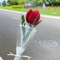 Macro shot of a handmade red plush tulip flower bouquet with Love patterned wrap - Vintage Red Tulip with Pearl Gauze
