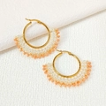 Detail of handmade fan-shaped gold earrings with white pearls and peach faceted beads - Pink