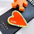 Cute red heart hair clip with colorful woven border and white lettering on a notebook - Heart-Orange