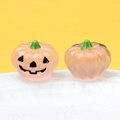 Detailed view of pink luminous resin pumpkins with smiling faces on a white plate - Luminous Light Pink (Black Expression)