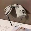 Detail of a large silver-grey satin bow hair clip on a minimalist black headband - Gray (Headband)