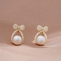 Close-up of golden bow earrings with white zircon pave setting and round pearl detail - Gold Bow Pearl (31# Silver Needle)