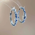 Macro shot of large blue denim C-shaped hoop earrings with stylish frayed edge texture - Silver Earring Post-Blue