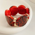 Detalle de eslabones de resina con estampado de leopardo rojo y cuentas doradas en brazalete - Rojo