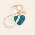 Dettaglio portachiavi a cuore con strass blu pavone, perle e moschettone dorato - Blu pavone con cinturino di perle
