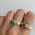 Golden and silver spiral rings featuring blue enamel flowers with yellow smiley faces - US 7 / Blue Wavy Smiley Flower