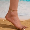 Detailed beach view of a double-layer gold anklet with star pendant and white enamel charm - Gold Star Anklet