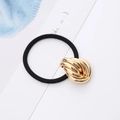 Detailed shot of black elastic hair tie with a decorative golden metal knot ornament - Bud Shape