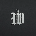 Macro shot of silver Old English letter M charm in stainless steel on textured background - Letter W