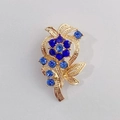 Vintage-Blumenbrosche in Gold mit tiefblauen Straßsteinen und hellblauen Akzenten - Vintage blaue Zweigblume