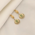 Detailed view of gold hoop earrings with green oval stone and filigree on white silk - Green Gemstone Earrings