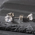 Detailed view of 6mm round cubic zirconia stud earrings with a 4-prong stainless steel setting - 6mm / Silver
