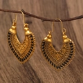 Detail of vintage bohemian hollow carved heart earrings hanging on natural wood branch - Antique Gold 0881