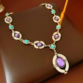 Detalle de collar vintage dorado con gema púrpura y detalles en color turquesa - Collar N.° 32 - Dorado - Morado - Azul