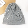 Détail du bonnet en maille grise avec perles blanches élégantes et strass brillants - Gris clair