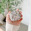 Nahaufnahme einer Hand mit funkelnder AirPods-Hülle mit bunten Strasssteinen besetzt - Lila Multi Strass / Airpods 3