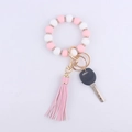 Detail of pink and white silicone beaded keychain bracelet with faux leather tassel - Pink
