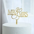 Golden acrylic Mr & Mrs wedding cake topper with reflective finish on a white cake - MR&MRS Gold Hollow Style