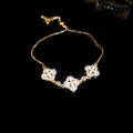 Detail of adjustable gold bracelet with white enamel flower petals and zircon stones - Clover Drawstring Style / Gold