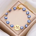 Gold evil eye beaded bracelet featuring a letter N pendant and blue charms - Letter N