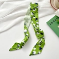 Green twilly silk scarf with white floral patterns and elegant handwritten script design - Kapok Green