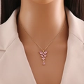 Collana a farfalla dorata con cristalli rosa indossata da modella in giacca bianca - Rosa