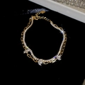 Detail of 18k gold plated double layer bracelet with zircon stones on black background - Gold