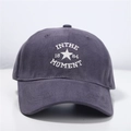 Close-up of embroidered IN THE MOMENT text on dark grey cotton twill baseball cap - One Size (Adjustable) / Gray