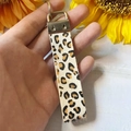 Dettaglio di un portachiavi in vera pelle leopardata con anello metallico e texture - Stampa Leopardata Bianco Nero