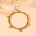 Golden stainless steel heart charm bracelet with paved rhinestones on warm background - Gold Bracelet / Gold