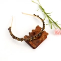 Close-up of handmade gold headband with tiger eye stones on carved wood base - Gold + Double Row Tiger Eye