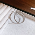 Detail of silver wavy texture round hoop earrings placed in a beige jewelry gift box - Silver Wave Texture Style