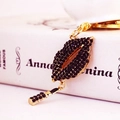 Fashion keychain featuring black rhinestone lips and lipstick pendant in gold finish - Black