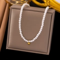 Elegant white pearl necklace with a central gold sphere pendant on a jewelry box - Pearl Necklace / Gold