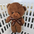 Orsetto di peluche marrone con nastro Love seduto in un cesto bianco traforato - caffè