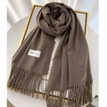 Close-up of thick coffee brown cashmere scarf with classic fringe and brand label - Dark Coffee