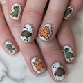 Cute cartoon dinosaur press-on nails with green and orange motifs on a white base - Yellow Jelly Glue + Nail File