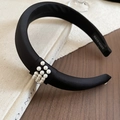 Close-up of black satin padded headband with triple row white pearl accent and handmade label - Black