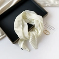 Detail shot of a white pleated silk scarf elegantly knotted on a black display tray - 70*70cm / Pleated Milk White
