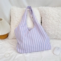 Détail du sac cabas en toile à rayures bleues et roses sur un lit blanc avec décorations - Style Seersucker à Bulles / Rayures Rose Bleu Blanc