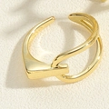 Detail of minimalist gold double-band adjustable ring on a textured base - Double Intertwined Style (JZ0335) / Gold