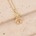 Detail of a gold teddy bear pendant set with pink and clear zircon stones on a beige stone - Pink and Clear Stone Teddy Bear (26#)