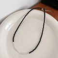 Minimalistische Perlenkette mit schwarzen Perlen und Silberakzenten auf einem Keramiktablett - Silberklumpen Perlenkette