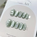 Detail of light green cat eye press-on nails with silver flowers and pearl accents - By1536 Shuxiang Bihua / Glue Type