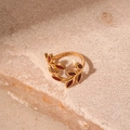 Nahaufnahme eines Vintage-Ringes mit goldenen Weinblättern und dunkelroter Emaille - Blattform / Rot