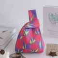 Small purple knit tote bag with red tulip patterns and a single knotted handle - Tulip Red